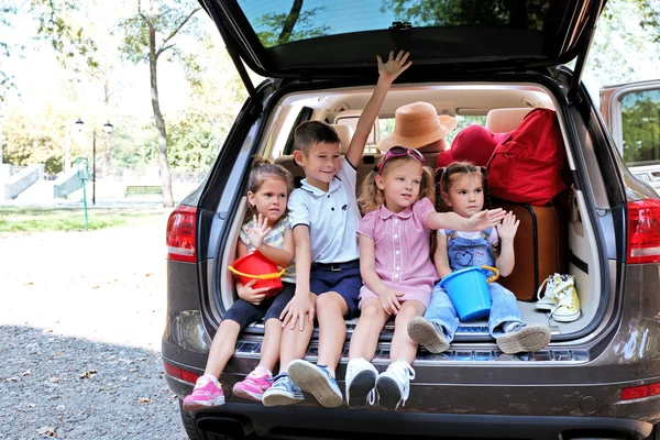 快乐的孩子坐在汽车后备箱 — 图库照片