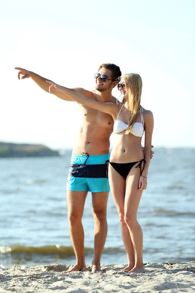 Szczęśliwa para, wskazując na plaży — Zdjęcie stockowe