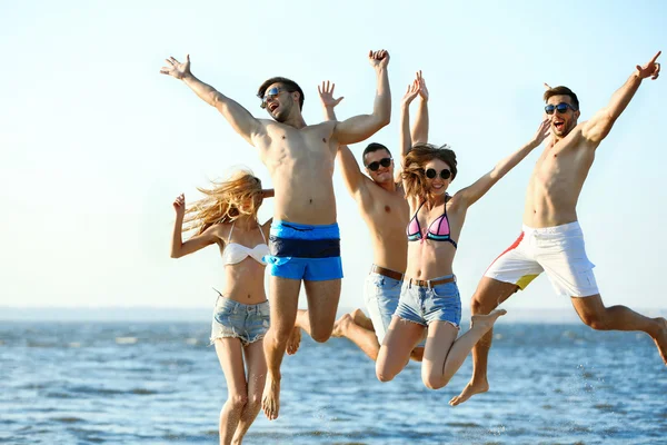 Happy friends jumping at beach — Stock Photo, Image