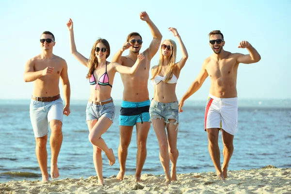 Amigos felizes correndo na praia — Fotografia de Stock