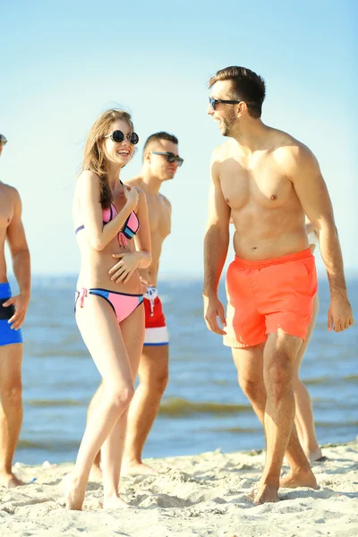 Happy couple and friends relaxing at beach — Stock Photo, Image