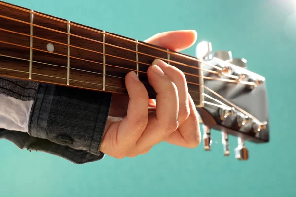 Guitars neck in musician hands on blue background, close up — Stock Photo, Image
