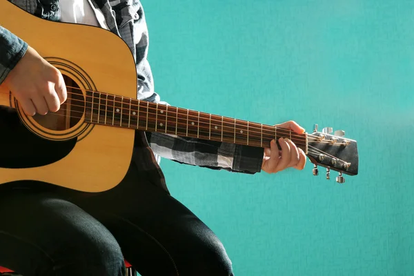 Musician plays guitar on blue background, close up — Stock Photo, Image