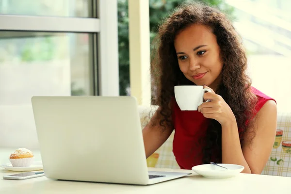 Kvinna med laptop dricka kaffe — Stockfoto