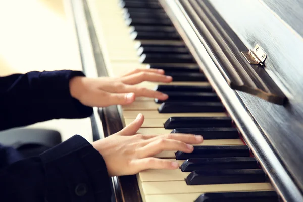 Attractive little girl plays piano — Stock Photo, Image