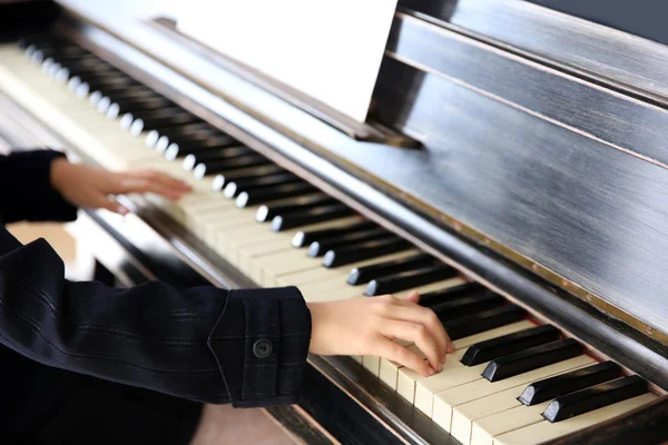 Закрыть руки маленькой девочки, играющей на фортепиано — стоковое фото