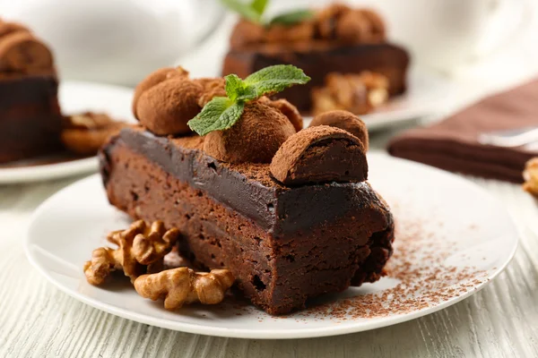 Stück Schokoladenkuchen mit Walnuss und Minze auf dem Tisch, Nahaufnahme — Stockfoto