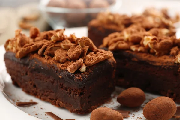 Bitar av choklad kaka med valnöt på bordet, närbild — Stockfoto
