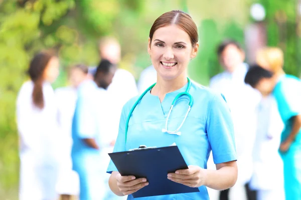 Güzel Bir Kadın Doktor Ile Sağlık Görevlilerinin Açık Havada Odaklanmamış — Stok fotoğraf