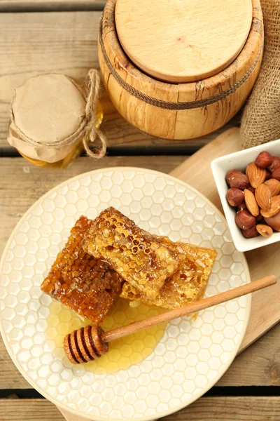 Honeycombs on plate on wooden background — Stock Photo, Image