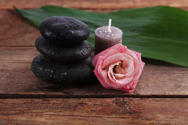 Piedras de spa, una vela y una rosa — Foto de Stock