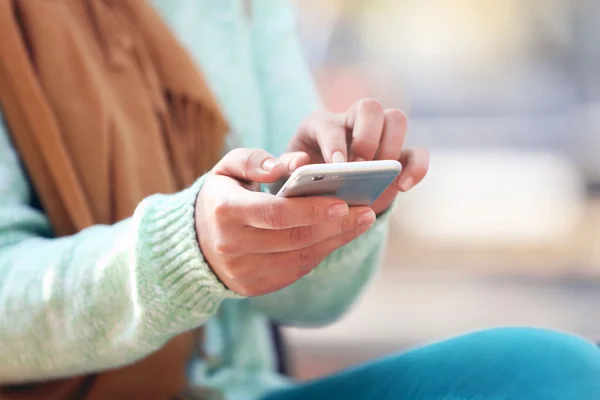 Mãos femininas segurando um telefone celular — Fotografia de Stock