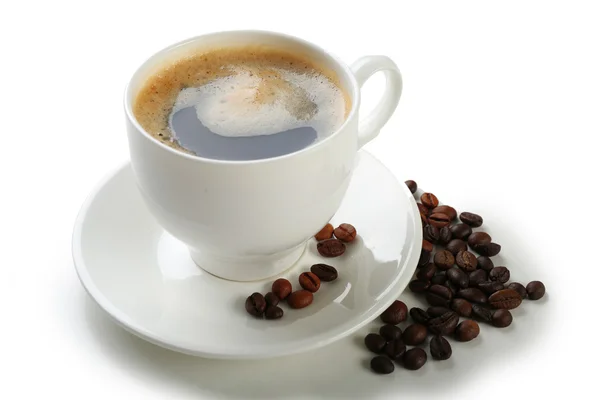 Een kopje van smakelijke drank en verspreide koffie korrels, geïsoleerd op wit — Stockfoto