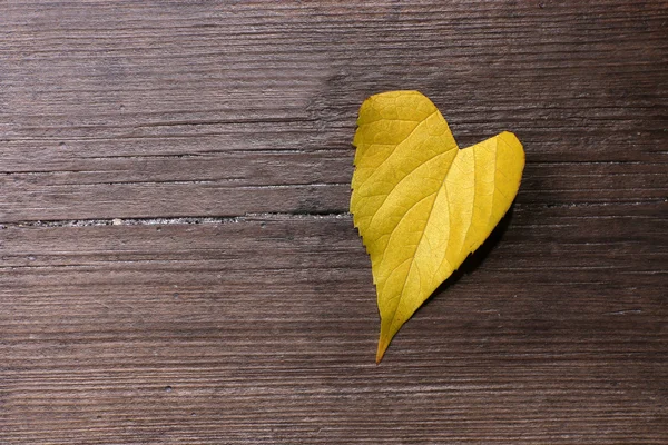 Feuille jaune sur fond en bois — Photo