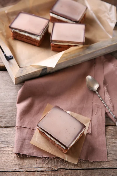 Deliciosos brownies de chocolate en bandeja, sobre fondo de madera — Foto de Stock