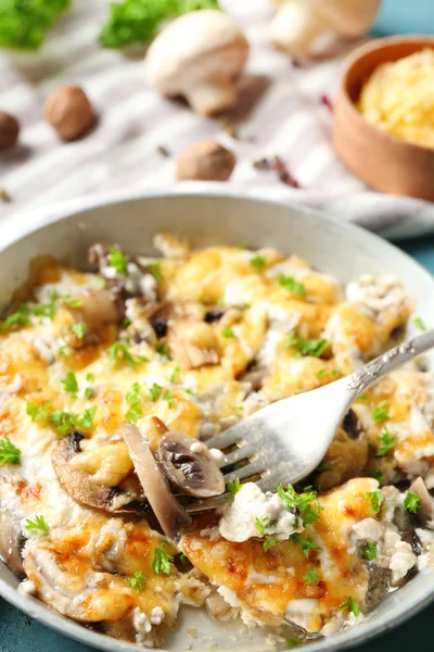 Roasted mushrooms, chicken and cheese gratin in pan, on color wooden background — Stock Photo, Image