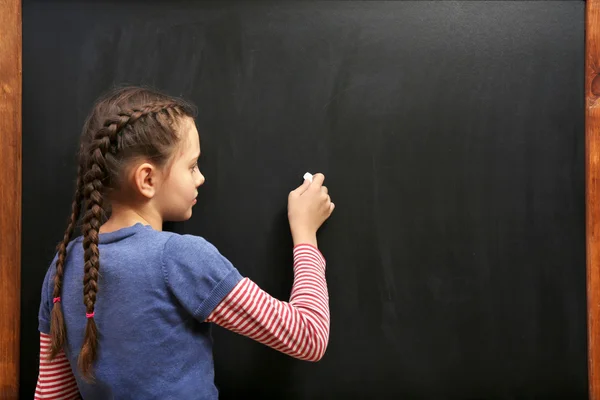 Meisje die zich voordeed op schone blackboard — Stockfoto