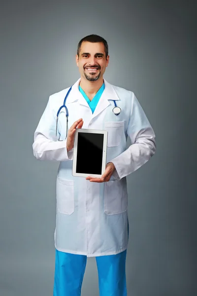 Retrato de un médico con un comprimido en las manos —  Fotos de Stock