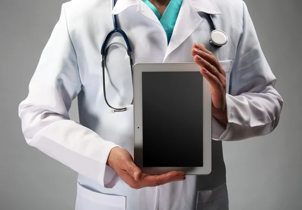 Médico segurando comprimido nas mãos — Fotografia de Stock