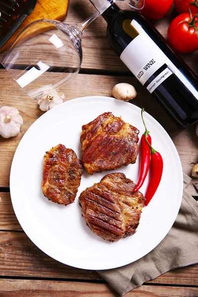 Filete de ternera asada en plato, sobre fondo de madera — Foto de Stock