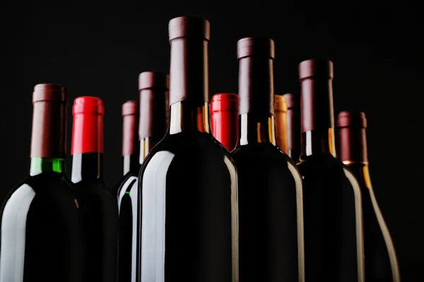 Botellas de vino sobre fondo negro, de cerca — Foto de Stock