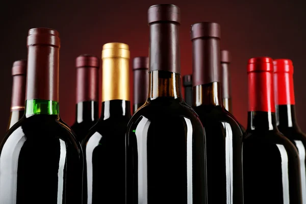 Botellas de vino sobre fondo rojo — Foto de Stock