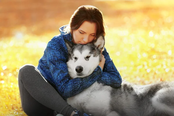 공원에 그녀의 강아지와 함께 앉아있는 여자 — 스톡 사진