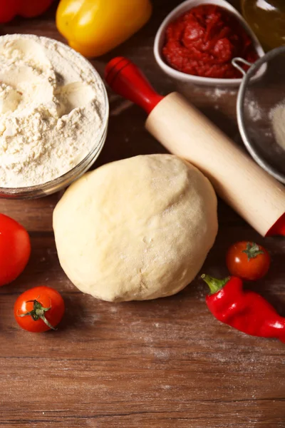 Ballen van deeg en ingrediënten voor pizza, op de tafel — Stockfoto
