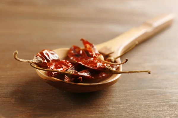 Wooden spoon with dried chili on the table, close-up — Stock Photo, Image
