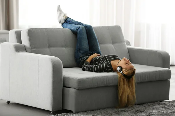 Ung kvinna ligger på soffan — Stockfoto