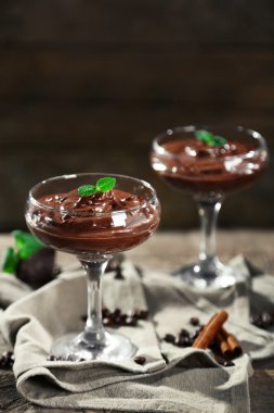 Ahşap arka plan üzerinde bardaklarda çikolata tatlı