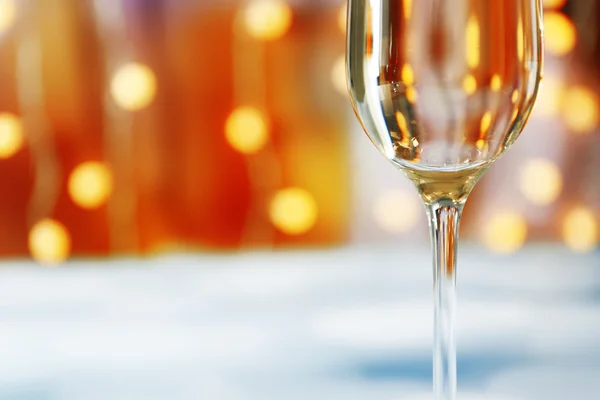 Una copa de champán sobre fondo borroso iluminado —  Fotos de Stock