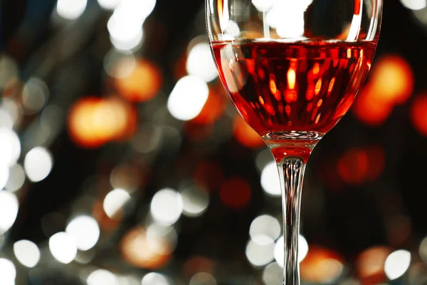 Una copa de vino rosa sobre fondo borroso iluminado — Foto de Stock