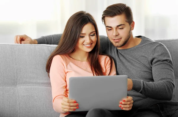 Unga lyckliga paret med laptop — Stockfoto