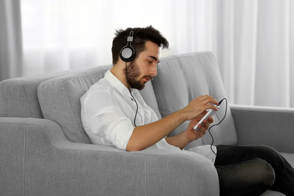 Joven escucha música con auriculares — Foto de Stock