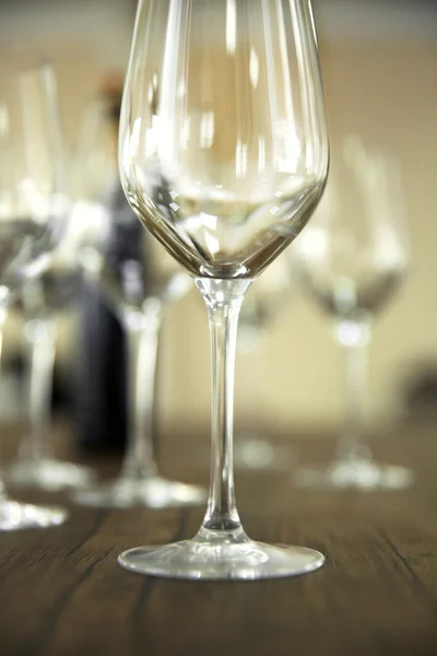 Vasos de vino vacíos con botella sobre mesa de madera sobre fondo borroso — Foto de Stock