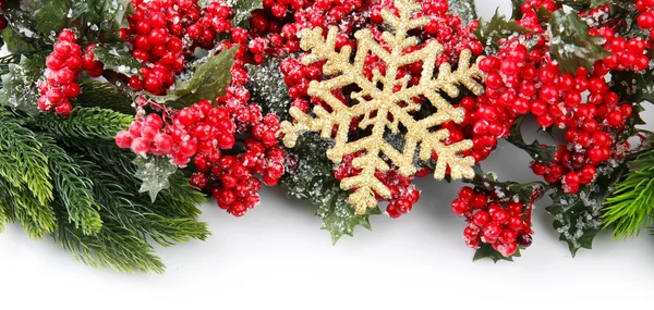 Rama de árbol de Navidad con bayas rojas y copo de nieve dorado sobre fondo blanco —  Fotos de Stock