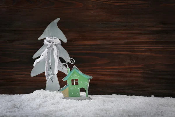 Fir tree and house in the snow over wooden background, still life — Stockfoto