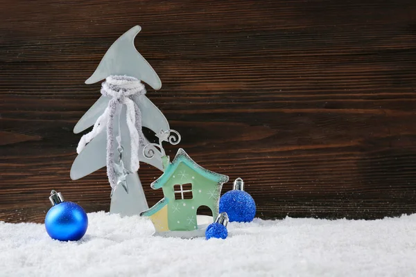 Елка, голубые безделушки и дом в снегу на деревянном фоне, натюрморт — стоковое фото