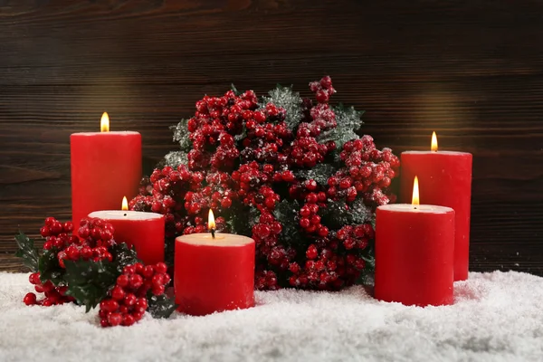 蜡烛和冬青浆果在雪在木制背景，静物的分支 — 图库照片