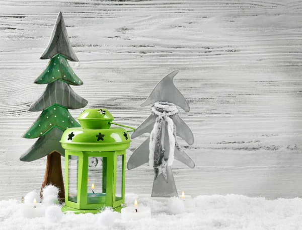 Grüne Lampe, Tannen, Kerzen im Schnee vor hölzernem Hintergrund, Stillleben — Stockfoto