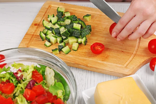 Frauenhände schneiden Gemüse für Salat, in der Küche — Stockfoto