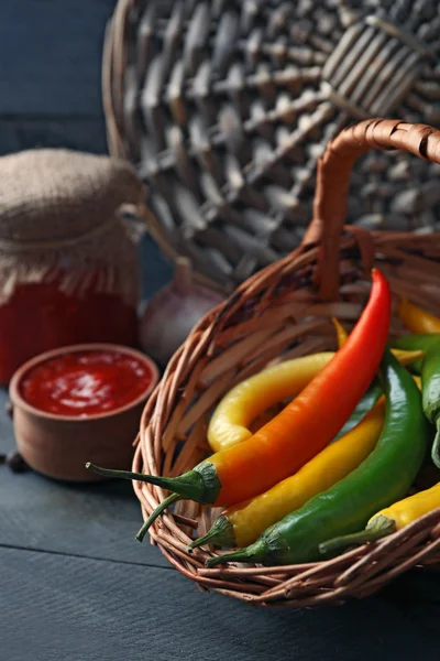 Chili peppers v proutěném koši — Stock fotografie