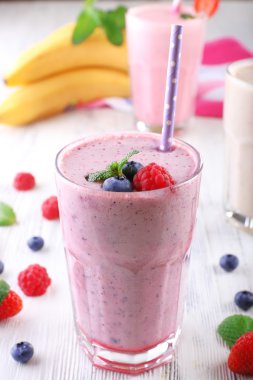 Milkshakes hafif ahşap arka plan üzerinde çilek ile yakın çekim