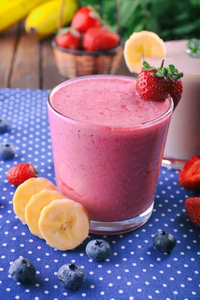 Bicchieri di frullato fresco freddo con frutta e bacche, su fondo tovaglia blu — Foto Stock