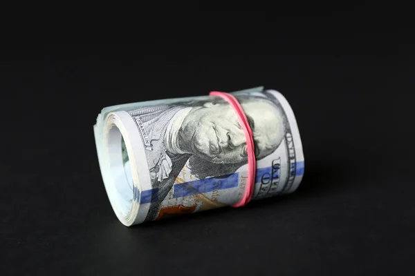 Dollar rollen auf schwarzem Hintergrund — Stockfoto