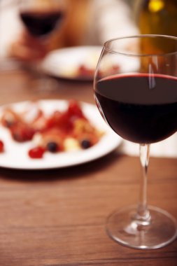 Masada kırmızı şarap bardağı var.