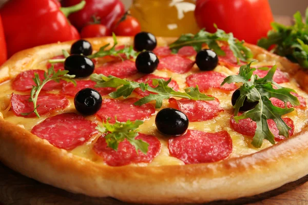 Pizza saborosa com salame na mesa de madeira decorada, close-up — Fotografia de Stock