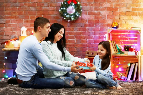 Parents give present to the daughter in the decorated Christmas room — Stock Photo, Image