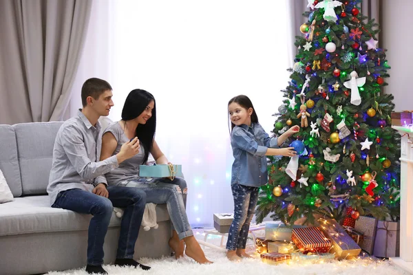 Familia feliz con regalos en la habitación de Navidad decorada — Foto de Stock